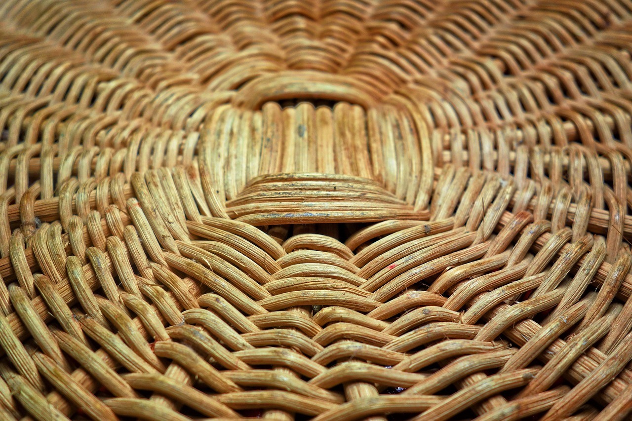 A close-up reveals tightly interlaced cane strips forming a radial basket pattern.
